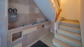 Un escalier moderne avec une main courante en bois et un terminal de paiement fixé au mur.