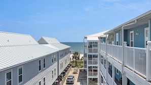 A multi-story hotel with balconies, a parking area, and a view of the ocean. - Recently refurnished condo directly on the beach! (Gulf Shores)