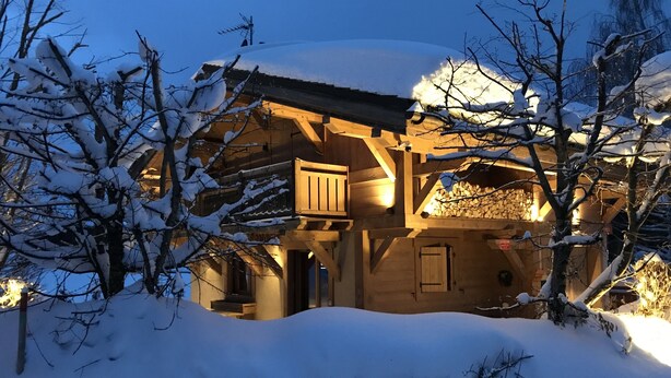 A wooden cabin with a balcony, surrounded by snow-covered trees. - Chalet Individual warm  (Megève)