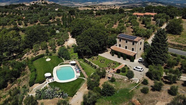 Une vaste villa dotée d’une piscine, entourée d’une végétation luxuriante et offrant une vue sur un paysage montagneux.