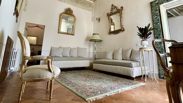 Un vaste salon doté d’un haut plafond, d’un décor orné et de meubles classiques.