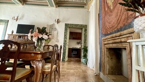 Un coin repas avec une table et des chaises en bois, un lustre et une vue sur la cuisine.