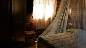 A bedroom with a bed, a chair, and a window with curtains. - Rural house capacity from 2 to 16 people, house for 12 and suitable for 2/4 pax (San Carlos del Valle)