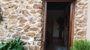 A stone building with a wooden door and a potted plant beside it. - Rural house capacity from 2 to 16 people, house for 12 and suitable for 2/4 pax (San Carlos del Valle)