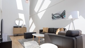 Een moderne woonkamer met een bank, salontafel en een flatscreen televisie.