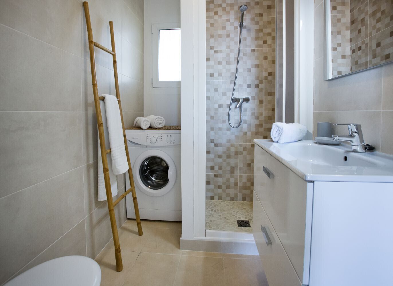 Un baño moderno con lavadora, ducha y lavamanos.