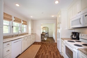 Enjoy cooking in this well-equipped kitchen with a granite countertop, stainless steel appliances, and ample natural light.