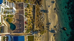 An aerial view of a resort with a pool, beach, and clear turquoise waters. - Tranquil and Relaxing Beachfront Condo with Exceptional Views! (Los Barriles)