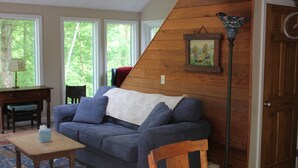 Ein gemütliches Wohnzimmer mit einem blauen Sofa, einem Holztisch und einer Lampe.