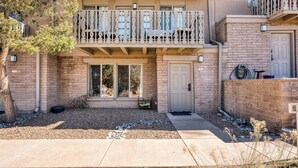 A two-story building with a balcony, large windows, and a door. - Casa Bohemia | Charming Retreat (Santa Fe)