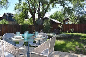 Relax in a serene backyard setting with a round table and comfortable seating.