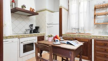 A compact kitchen with a Bosch dishwasher, a coffee maker, and a refrigerator.