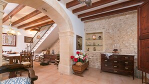 A rustic interior with exposed wooden beams, a stone wall, and a staircase leading to an upper level. - CAN VALLORI - Nice house with interior terrace in Sencelles. Free WiFi (Sencelles)