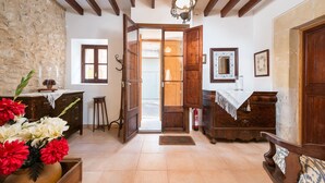 A room with wooden furniture, a stone wall, and a door leading to another room. - CAN VALLORI - Nice house with interior terrace in Sencelles. Free WiFi (Sencelles)