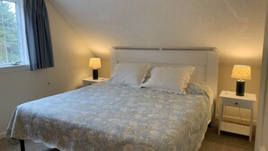 A bedroom with a bed, two bedside tables, and a window with curtains. - Oceanfront Carriage House Apt. w/ Spectacular Views (York)