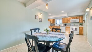 A dining area with a round table, four chairs, and a vase of flowers. - Starstorm Mountain Apartment
Lakeview deck & hiking trail, near many activities. (Lake Junaluska)