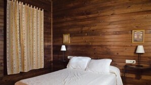 A wooden-paneled room with a bed, two bedside lamps, and a curtain. - Self catering Vallehermoso for 12 people (San Carlos del Valle)