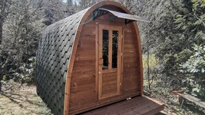 Eine Holzhütte mit geneigtem Dach, einer Haustür und einer kleinen Veranda.