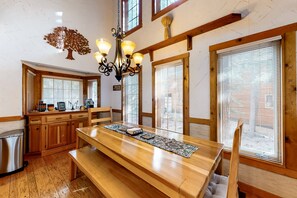 Enjoy meals in this traditional dining area with a long table for two and a bench.