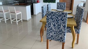 Eine moderne Küche mit Granit Arbeitsplatten, einer zentralen Kochinsel und einem Essbereich mit gemusterten Stühlen und einem Holztisch.