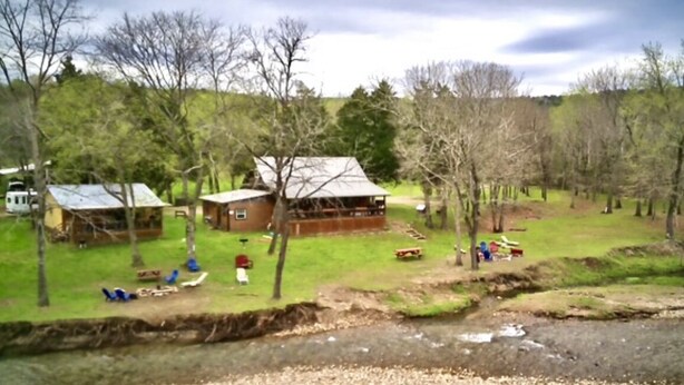 A rural property with a large wooden house, a smaller cabin, and a barn. There are trees and a grassy area with a stream. - Liberty Cabin on Collier creek!! In Caddo Gap (Norman)