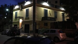 A two-story building with a balcony, a gated entrance, and parked cars in front. - VILLA ROSA - Apartment n. 2 "GIGLIO" (4 beds): (Napoli)