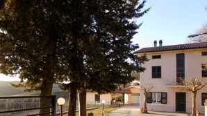 A paved pathway leading to a building with a tiled roof and a balcony. - CA'LAMBRUSCO App. CRI (4 + 2 PEOPLE) (Smirra di cagli)