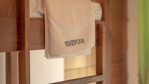A wooden bed frame with a towel hanging on it that reads "BOHEMIAN". - Bohemian Hostel - Negombo (Negombo)