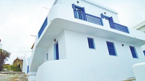 Un edificio blanco con detalles azules, incluyendo ventanas y un balcón.