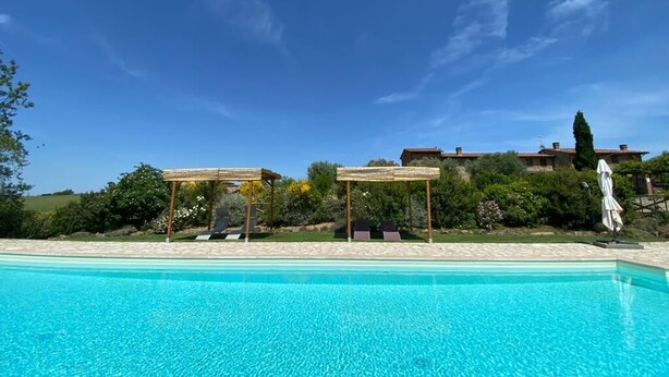 A clear blue pool with lounge chairs and a pergola. - Desiderio, luxury home with pool AC, WIFI and cook school - A Fontanaro Property (Paciano)