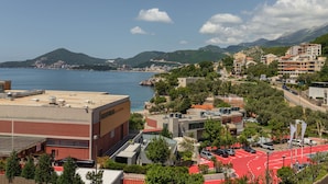 A coastal town with buildings, a beach, and mountains in the background. - Apartments My Przno - Apartment with Side Sea View 4 (Przno, Budva)