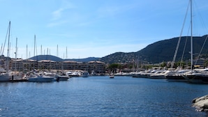A marina with boats docked, surrounded by buildings and hills. - Panoramic sea view, swimming pool, garden. 
Quiet & comfortable, refurbished  (Cavalaire-sur-Mer)