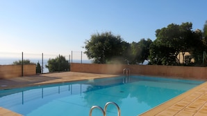 A rectangular swimming pool with a clear blue water surface, surrounded by a tiled deck. - Panoramic sea view, swimming pool, garden. 
Quiet & comfortable, refurbished  (Cavalaire-sur-Mer)