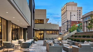 Un patio exterior con muebles de mimbre y una chimenea.