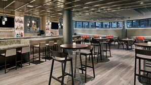 Zona de bar moderna con asientos y mostrador.