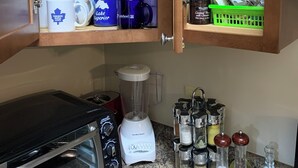 Une cuisine équipée d’un four encastré, d’un mixeur et de divers ustensiles et récipients de cuisine.