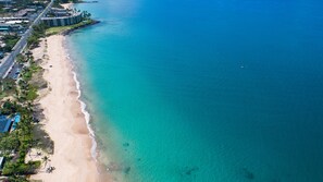 Rannalla, aurinkotuoleja, aurinkovarjoja, rantapyyhkeitä