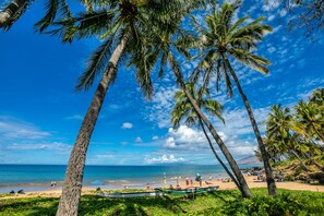 Rannalla, aurinkotuoleja, aurinkovarjoja, rantapyyhkeitä