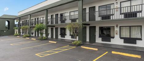 Un motel de varios pisos con un estacionamiento.