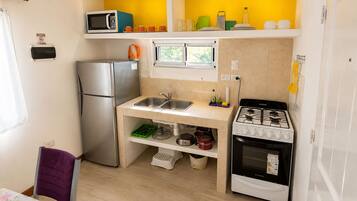 Una kitchenette compacta con refrigerador, microondas, pileta y cocina.
