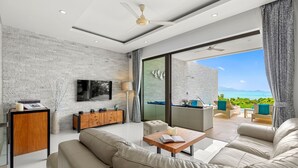 Uma sala de estar moderna com uma TV grande, um armário de madeira e um sofá.