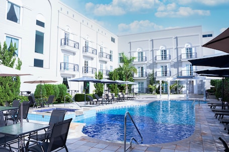 Una piscina al aire libre, sillones reclinables de piscina. Bisinii Hotel Boutique