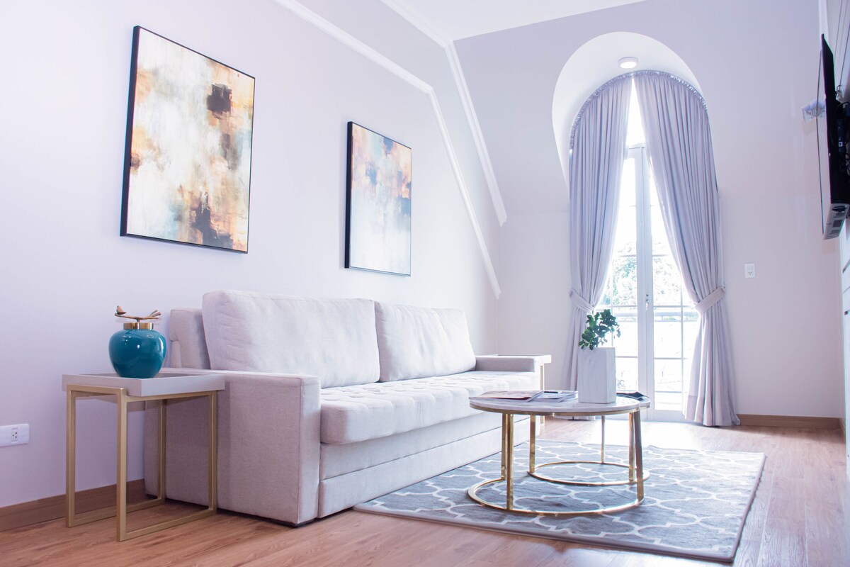 A modern living room with a sofa, a coffee table, and artwork on the walls.