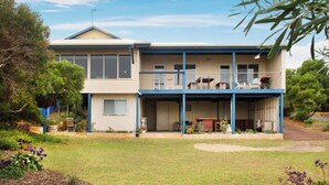 Uma casa de dois andares com varanda coberta e garagem.