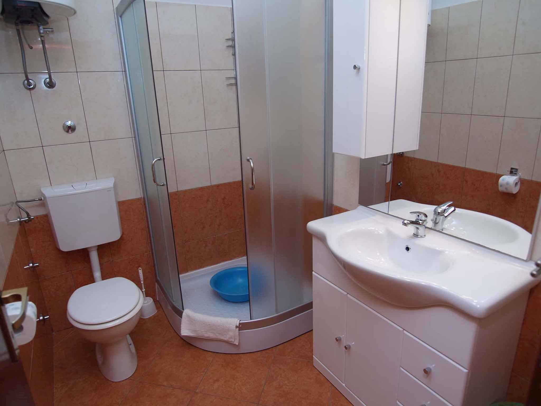 Un baño con inodoro, cabina de ducha y lavabo con espejo.