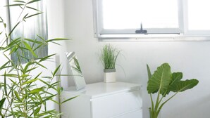 A room with a white dresser, a potted plant, and a window with blinds. - Zen Retreat (San Juan)