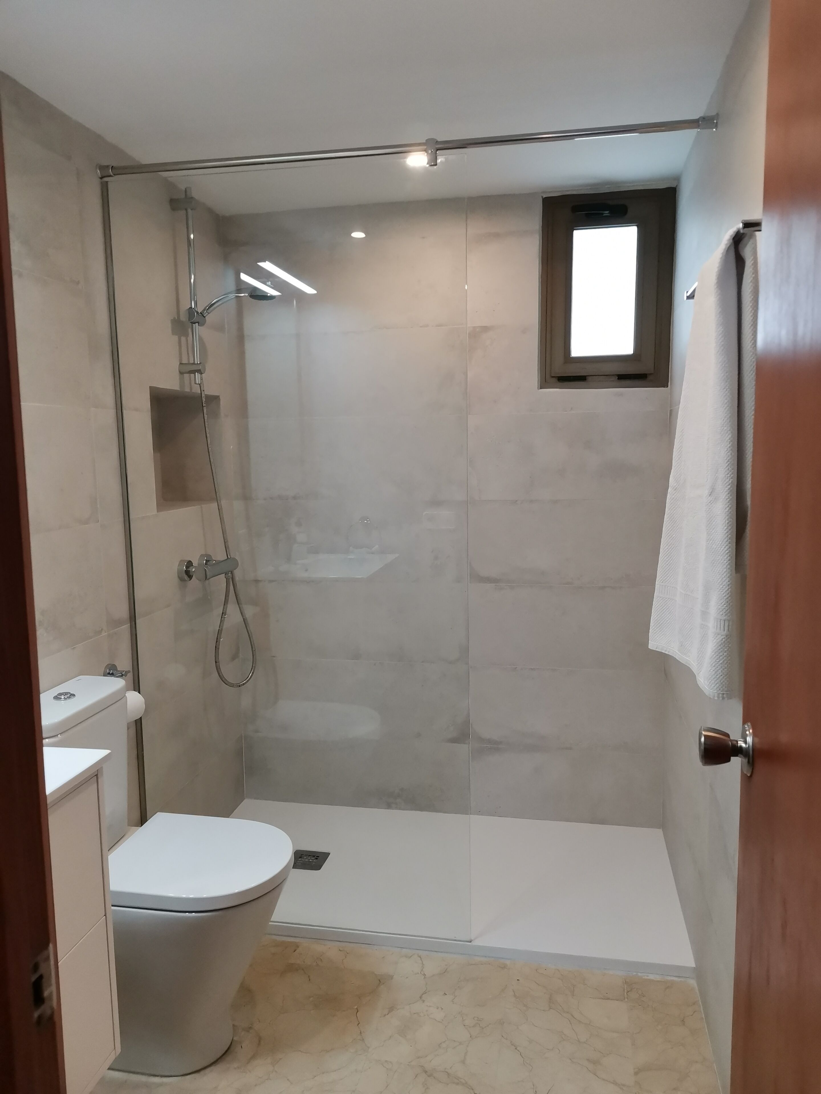 Een bad/douchecombinatie, een haardroger, handdoeken, toiletpapier