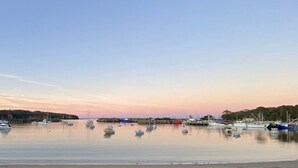 Una marina con imbarcazioni ormeggiate in acque calme al tramonto.