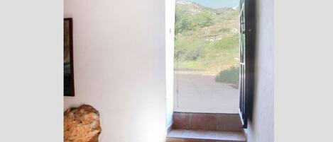 A staircase leading to a balcony with a view of a hilly landscape.