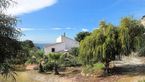 A white building with a tiled roof, surrounded by greenery and trees. - Gorgeous Andalusian house in a protected Nature Reserve (Nerja)